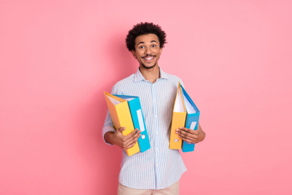 Homme souriant sur fond rose, heureux de bénéficier d’une couverture de prévoyance adaptée aux besoins des PME.